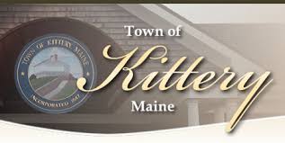 A sign displaying the words Town of Kittery Maine in large script, with the town seal in the background featuring a lighthouse and coast.